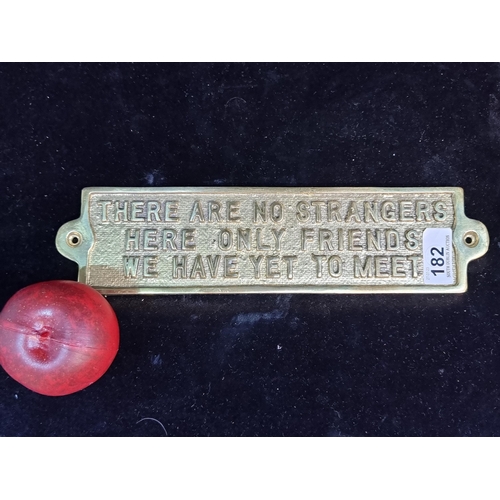 182 - A heavy polished brass sign reading ''There Are No Strangers Here Only Friends We Have Yet To Meet''