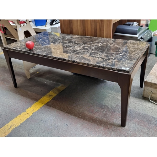 437 - A very good coffee table with a black marble  top and wooden frame. In very good condition. 120cm x ... 