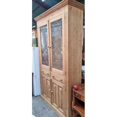 468 - A charming country kitchen style pinewood kitchen dresser. With lead muntins and two adjustable glas... 