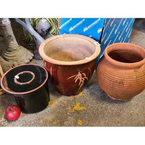 943 - Four planters including a large example with a bird motif, a terracotta example with a textured desi... 