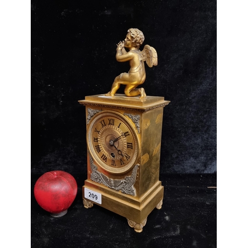 209 - A heavy quality antique brass mantle mechanical clock boasting a cherub finial.
