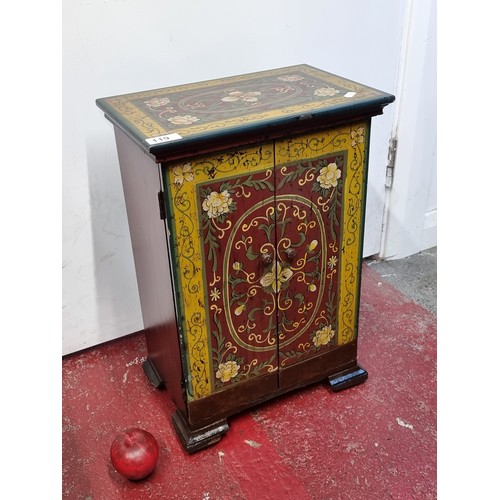 119 - A charming handpainted tabletop cupboard with handpainted front doors featuring floral motifs and ma... 