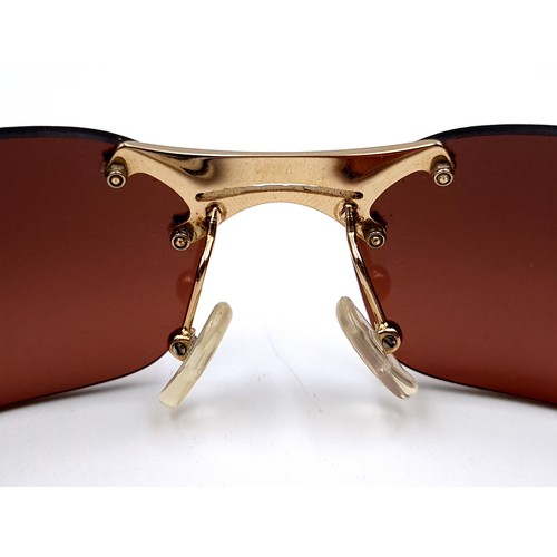 24 - A fabulous pair of early 2000's Dior wrap around sunglasses, featuring gold metal frames and cool br... 