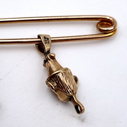 40 - A 9 carat gold (stamped 375) safety pin brooch. Weight: 2.08 grams. Which holds an intricate unmarke... 