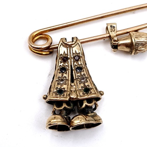 40 - A 9 carat gold (stamped 375) safety pin brooch. Weight: 2.08 grams. Which holds an intricate unmarke... 