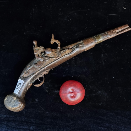 188 - An original antique flintlock pistol with heavy wooden butt and hammered brass banding. Possibly of ... 