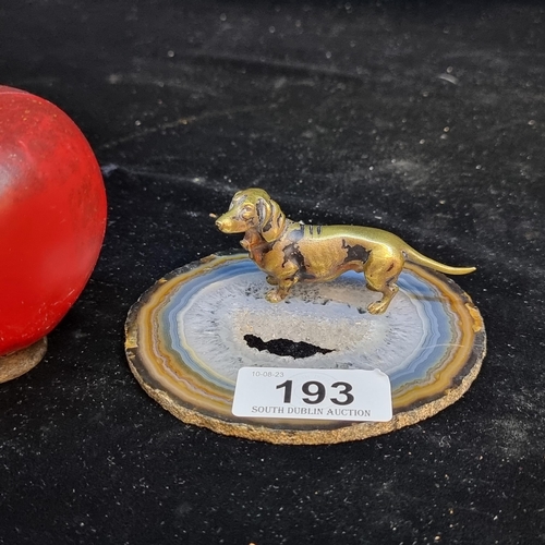 193 - An unusual brass dachshund figure mounted on an agate slice. Ideal as a paperweight.