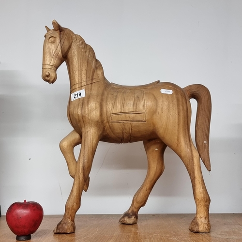 219 - A large handcarved wooden figure of a horse. Skillfully crafted from a single piece of wood. H50cm