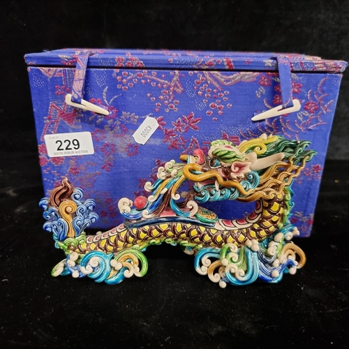 229 - A highly ornate Chinese ceramic figure of a traditional dragon in vibrant shades of green, yellow, b... 