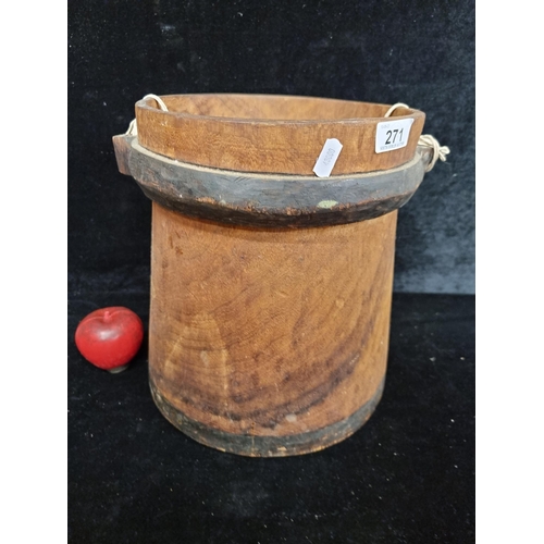 271 - A wooden hand crafted  bucket crafted from a single piece of wood. With carved fittings for handle.