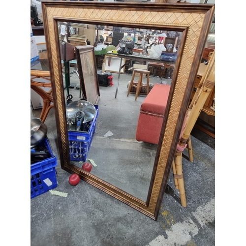 935 - A large wall mirror with bevelled glass and a gilded frame.  H76cm x W107cm