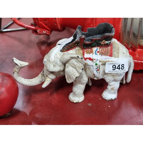 948 - A heavy cast metal figure of an elephant with an articulated trunk and tail.