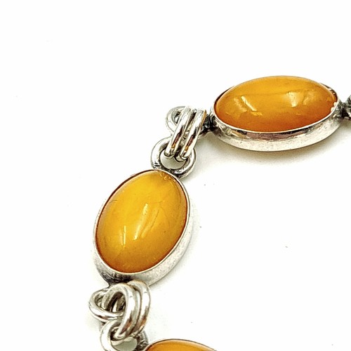 33 - A fine example of a sterling silver bracelet, featuring eight natural Butterscotch Amber stone setti... 