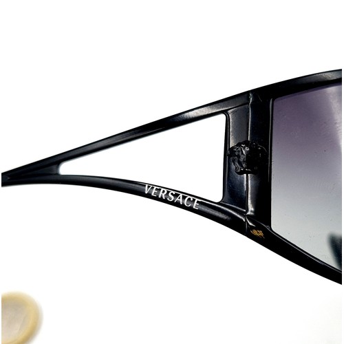 43 - A stylish pair of wrap around original designer Versace Italian made sunglasses. Featuring dark lens... 