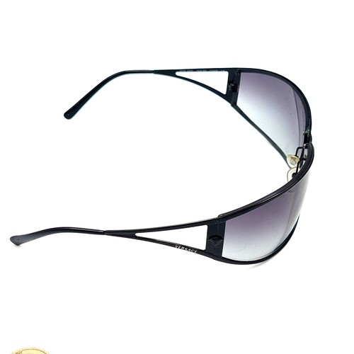 43 - A stylish pair of wrap around original designer Versace Italian made sunglasses. Featuring dark lens... 