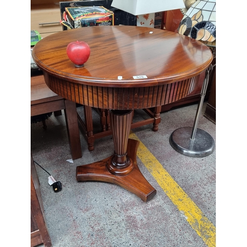 576 - A handsome drum table with tripod base and bun feet. Featuring reeded apron. As new. H77cm x D70cm