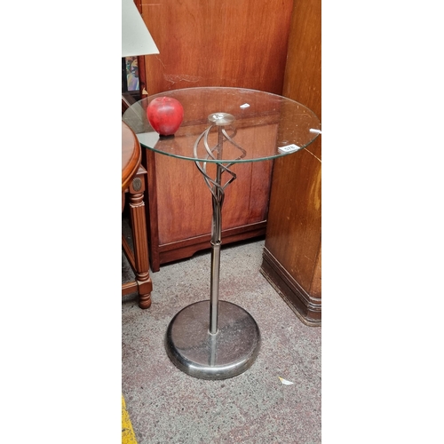 578 - A contemporary side table  with tempered glass top and cast metal stem with knop detail.