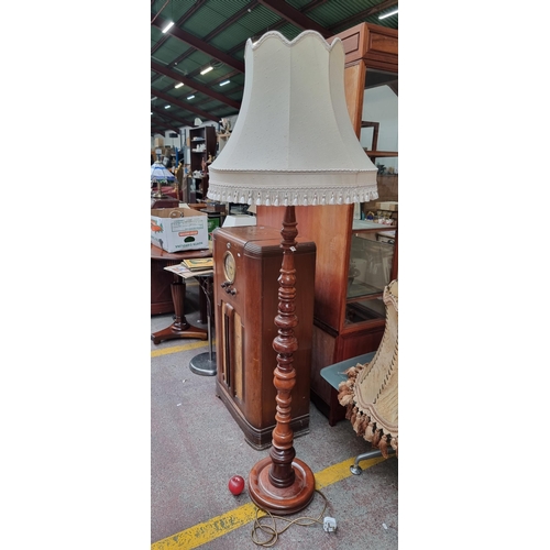 581 - A beautiful turned wood floor lamp with ornate knop stem. Topped with a champagne cream tasselled sh... 