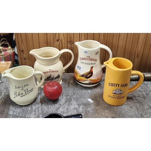 872 - A lot of four vintage ceramic whiskey jugs including Jogn Begg example by Wade.