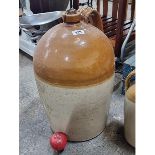 898 - A very large and heavy vintage stoneware flagon with original cork intact. Indistinct stamp to shoul... 