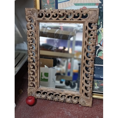 965 - An attractive carved wooden framed mirror. Very intricate carved foliate detail.