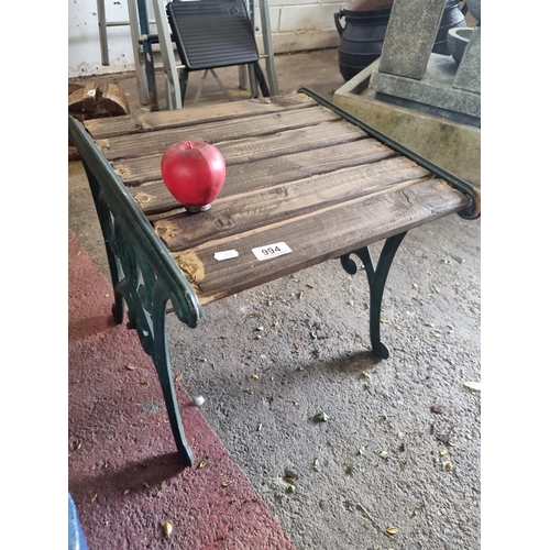 994 - A very heavy cast metal garden stool with green spiral frame and slatted wooden seat.