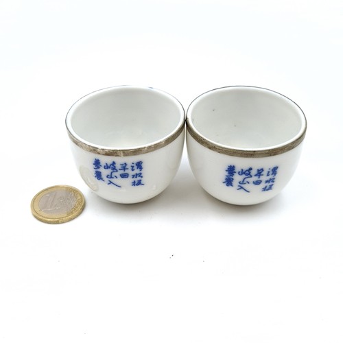 8 - A pair of antique  porcelain Japanese metal rimmed tea bowls, featuring scroll and traditional garde... 