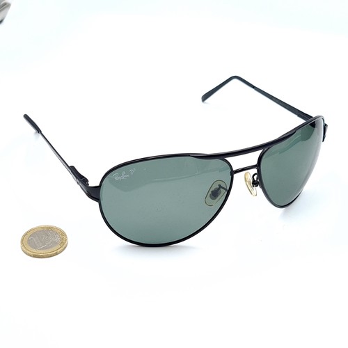 47 - A pair of genuine wrap around Ray-Ban faux black metal framed sunglasses, featuring dark lenses. In ... 