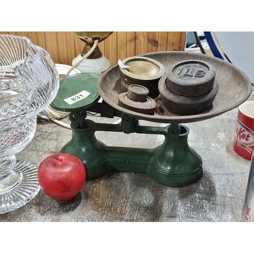 831 - A vintage cast iron grocer's scales. Featuring 5lbs and 10oz of weights. In a green finish.