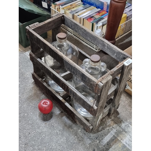 837 - Two vintage demi-john brewing bottles encased in a vintage wooden cage. The cage is stencilled ''M.W... 