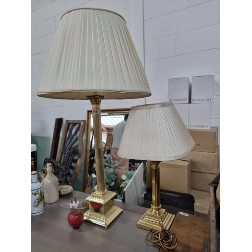 854 - Two elegant table lamps with reeded brass Columns  and cream pleated shades. Both with three-pronged... 