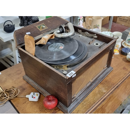 855 - A vintage His Master's Voice gramophone housed in a wooden. With three gramophone records, arm and a... 