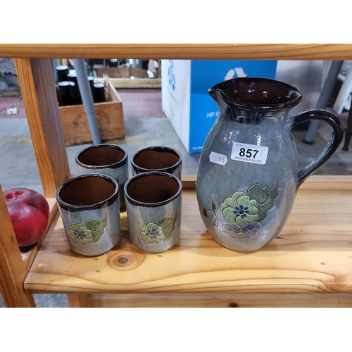 857 - Four earthenware cups / mugs with large jug. Lovely blue green glaze with floral motif.