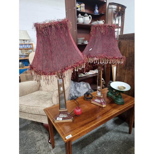 866 - A pair of unusual table lamps in a red and gold colour palette with mirrored stems and fringed and b... 