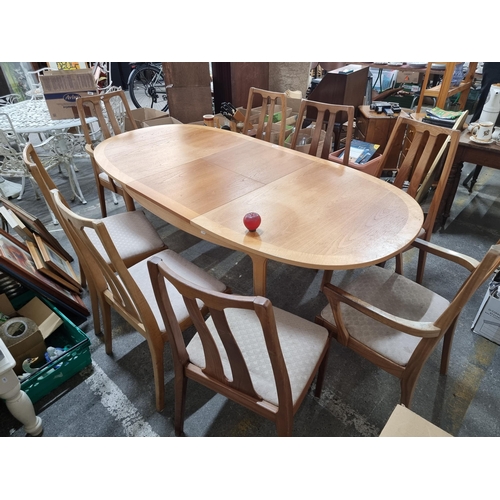 899 - Star Lot : A mid century  dining suite comprising of an extendable table and eight matching slatback... 