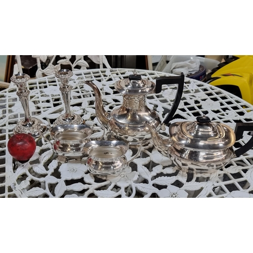 902 - A 4 piece EPNS tea set with hot water jug, a cream jug, sugar bowls and a pair of candle holders. Al... 