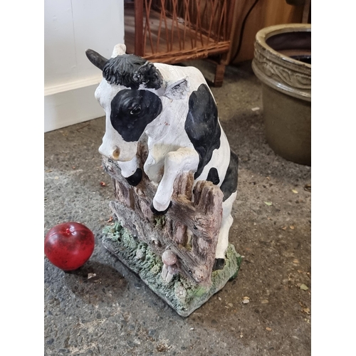 906 - A characterful heavy garden sculpture of a curious cow peering over a fence. Lovely hand painted fin... 