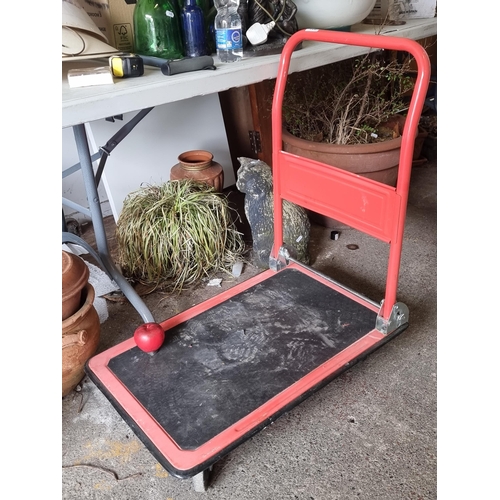 921 - An industrial four-wheel trolley with a handle, textured surface and castors to front. H82cm x L73cm... 