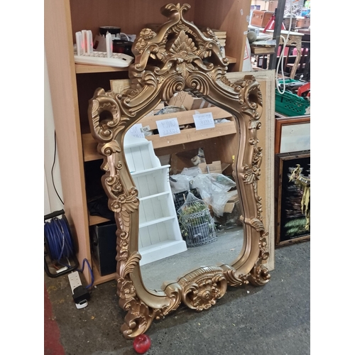 924 - A very large and lavish wall mirror held in an ornate frame. With fittings to the back. H138cm x W80... 