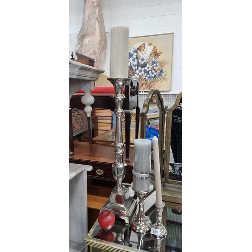 959 - A set of three silver toned cast metal candlesticks in varied styles and sizes. A nice eclectic trio... 