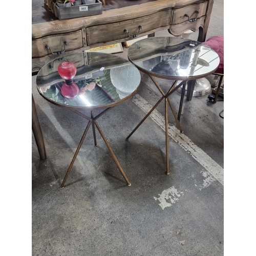 967 - A pair of striking side tables with brass tripod bases and foxed mirrored tops. Both in excellent co... 