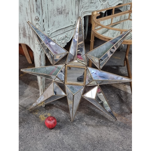 980 - A large wall hanging feature piece in the form of a star. Designed with a brass frame and faceted mi... 