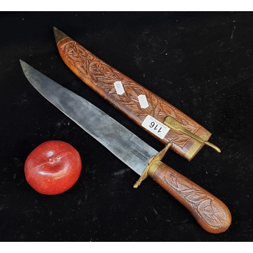 116 - A large vintage Indian knife with a nicely carved wooden sheath and handle featuring foliate design.... 