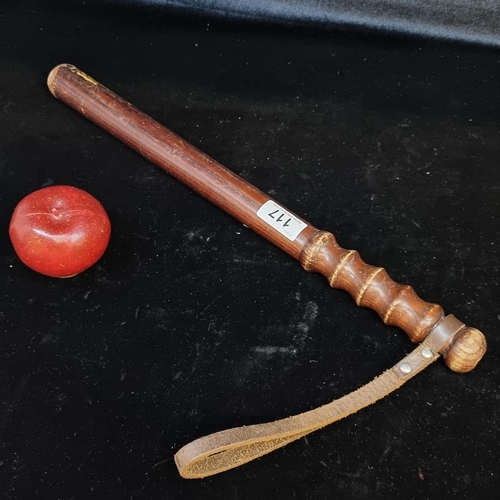 117 - A vintage Garda wooden baton with turned handle and leather strap.