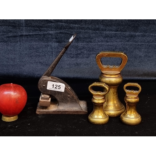 125 - Four antique items including three brass bell weights (4, 1 and 1 pounds). Along with an antique sta... 