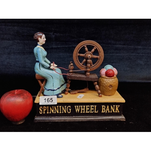 165 - A heavy cast metal money box in the form of a lady spinning yarn on a wheel. With articulated elemen... 