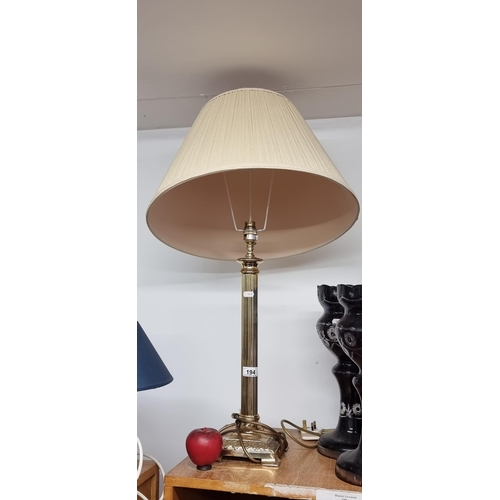 194 - An elegant very tall table lamp with polished brass corinthian column stem. Topped with a cream shad... 