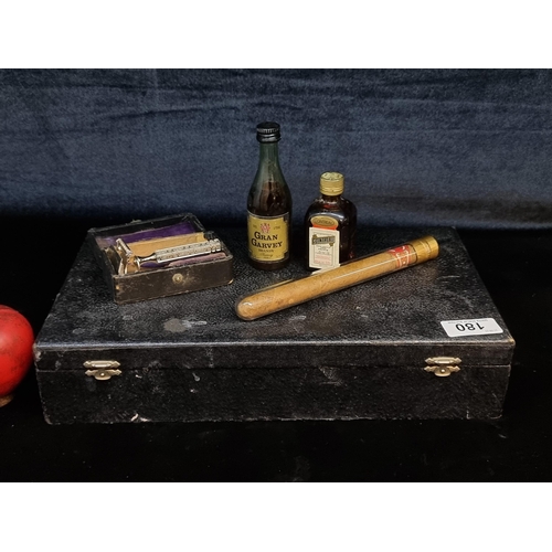 180 - A black case containing a Santa Cruz Breña Alta la Palma cigar in a sealed glass vial, a vintage raz... 