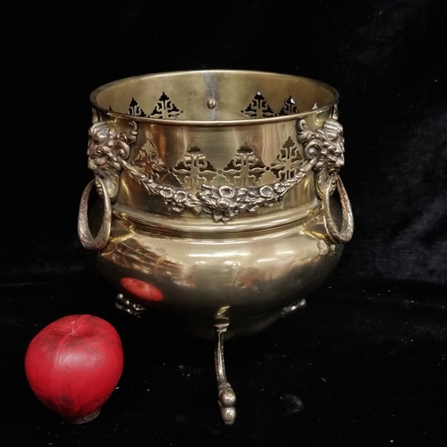 201 - A beautiful antique brass plant stand with lion mask handles, garland and lion paw feet. This has ju... 