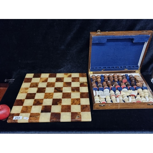 233 - A vintage marble chessboard along with a case set of marble chess/draughts pieces. Complete set.